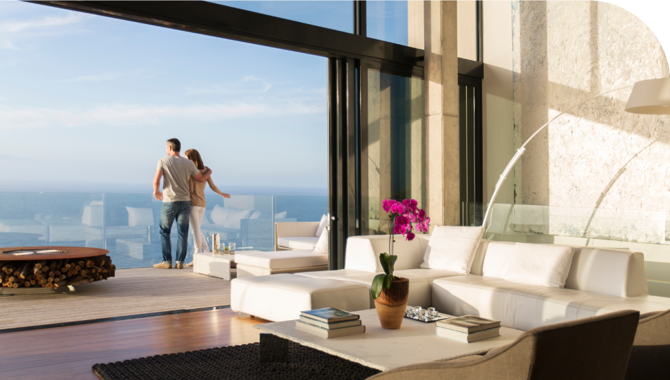 pareja mirando el mar mediterráneo de la Costa Blanca desde el balcón de su residencial