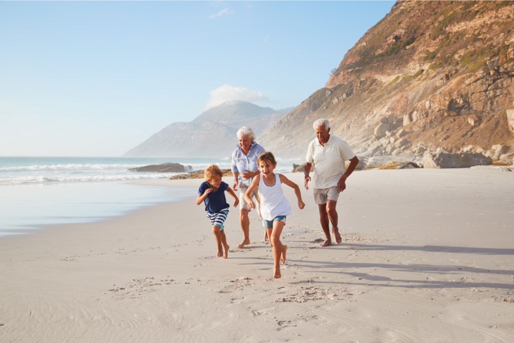 Abuelos y nietos corriendo por un playa de la Costa blanca