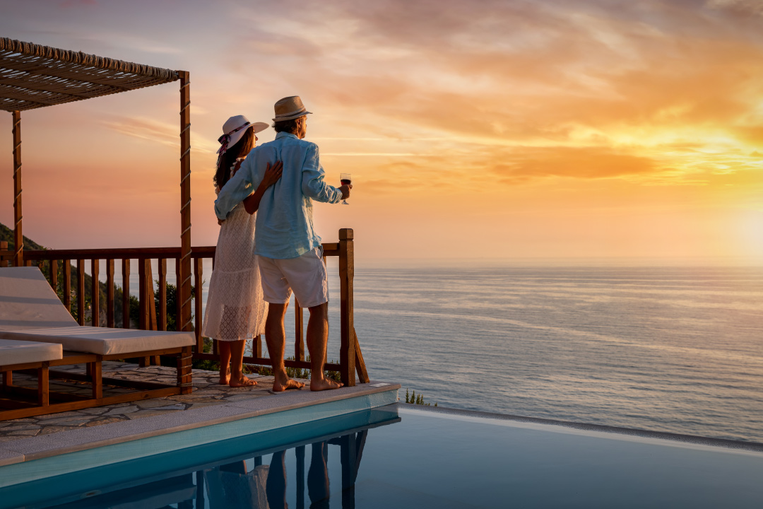 pareja mirando un atardecer en la terraza de su residencia de la costa blanca